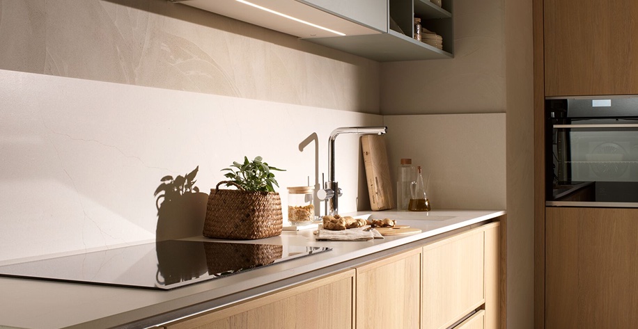 Oak kitchen worktop with woven plant pot and sunlight across drawers