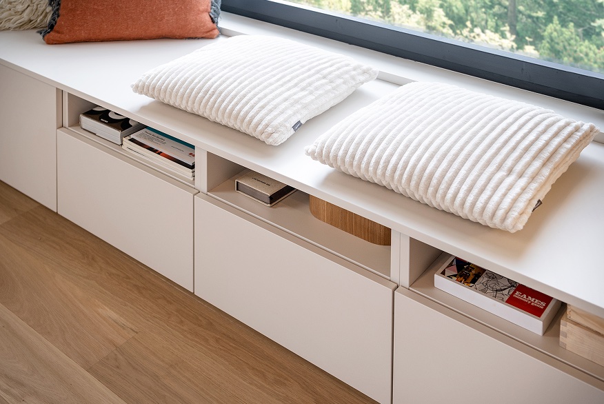 Window bench living space with white cushions and concealed storage